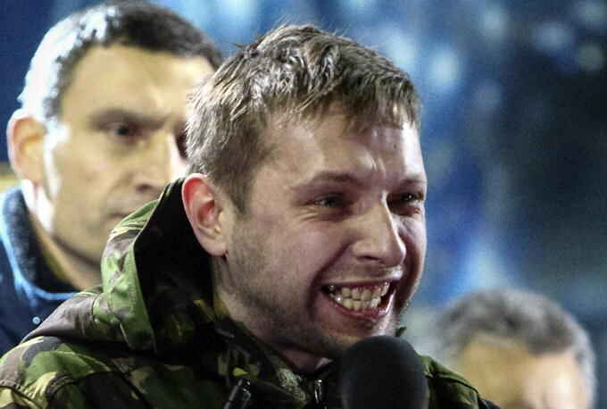 Anti-presidential protester Volodymyr Parasiuk addresses the crowd as opposition leader Vitaly Klitschko (L) looks on during a rally in Kiev February 21, 2014. When the history of the bloody turbulence in Ukraine is written, 26-year-old Parasiuk who learned combat skills in the army cadets may be recorded as the man who made up Viktor Yanukovich's mind to cut and run. To match Insight UKRAINE-CRISIS/HERO Picture taken February 21, 2014. REUTERS/Vitaliy Nosach (UKRAINE - Tags: POLITICS CIVIL UNREST PROFILE)