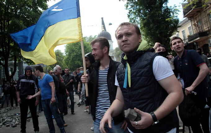 Ukrainian government supporters with a Ukrainian flag, prepare for a clash with pro-Russians in the Black Sea port of Odessa, Ukraine, Friday, May 2, 2014. A clash broke out late Friday between pro-Russians and government supporters in Odessa, on the Black Sea coast some 550 kilometers (330 miles) from the turmoil in the east. Odessa had remained largely untroubled by unrest since the February toppling of pro-Russia President Viktor Yanukovych, which ignited tensions in the east. (AP Photo / Sergei Poliakov)