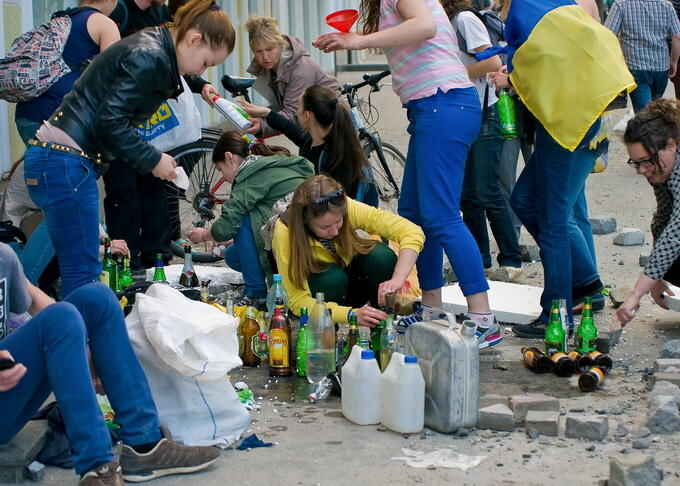 epa04189292 Young girls, supporters of a 'Single Ukraine' prepare Molotov cocktails as they clash with pro-Russian protesters in downtown of South-Ukrainian city of Odessa, Ukraine, 02 May 2014. At least one person was shot dead and more than ten people injured in the clashes.  EPA/SERGEY GUMENYUK